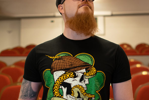 Dwight trägt das Shamrock Snake T-Shirt.